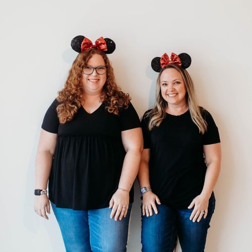 April Quesada and Heather leaning against a wall